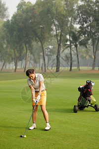 女高尔夫球手准备好击球图片