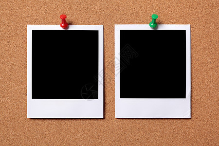 两张空白的照片印记被钉在软木通知板上图片