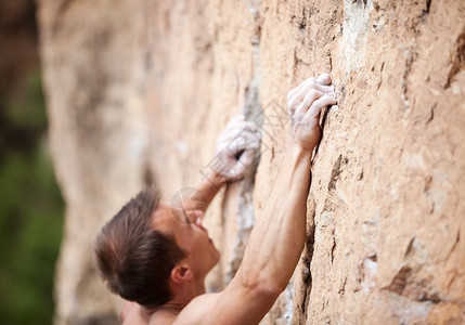 男在悬崖上攀岩者的切成的视图片