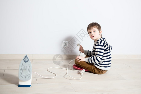 小男孩小男孩玩铁电线的危险游戏试图插入头图片