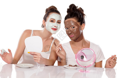 两个戴着白色背景面具的年轻女图片