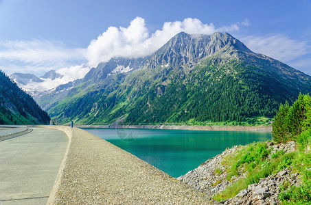 阿尔卑斯山脉高峰背景中的大坝和阿苏尔山湖图片