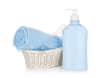洗发水瓶和蓝色毛巾在白色背景上孤立图片