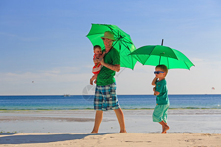 父亲和孩子在热带海滩图片