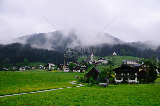 有山的小村庄在雨中图片