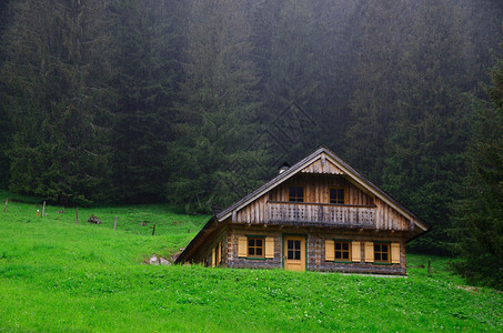 美丽的老木屋在山和大雨中图片