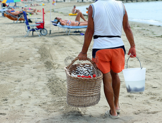 男人在海滩上卖水果用椰子草莓和甜瓜图片