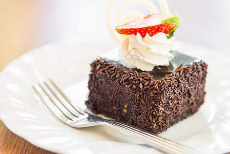 甜巧克力蛋糕在白盘上方有草莓水果图片