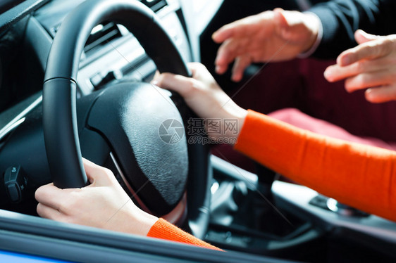 年轻女子用方向盘驾驶汽车图片