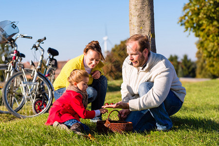与母亲父亲和女儿一起骑自行车或骑自行车在公园或乡村收图片