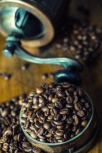 咖啡咖啡豆烤咖啡豆洒在一张木桌上用于研磨咖啡的图片