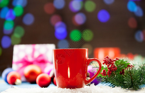 一杯茶和礼物背景是圣诞灯图片
