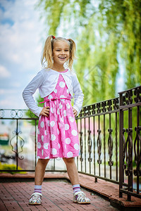 穿着粉红色裙子的美丽笑脸小女孩图片