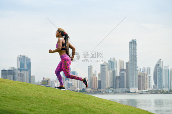 她骑在一座小山上直冲天际线跑来去的在城市清晨奔跑和锻炼的年图片