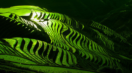 广西省瑶族少数民族村庄山谷和山丘上的日出背景图片