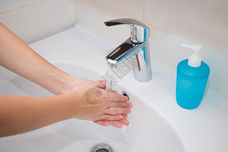 微生物菌女人在浴室里用肥皂洗手背景