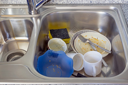 厨房水槽里的一小堆脏盘子图片