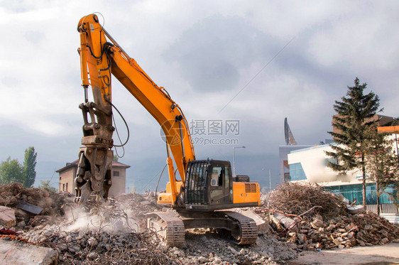 在城市环境中用重型机械拆除建筑物图片