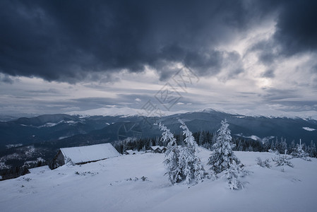 山里天气不好冬季景观多云的晚上有暴风云雪下牧羊人的木屋喀尔巴阡山脉图片