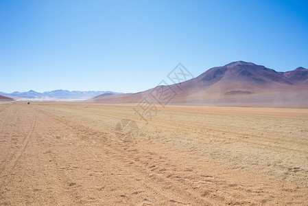 高海拔的土路与安第斯高地的沙质漠和贫瘠的火山范围背景图片