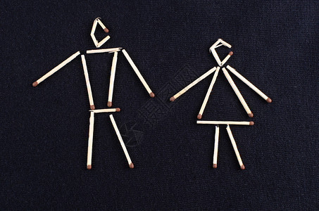 男和女形象在深色针织表面上布置火柴棍图片