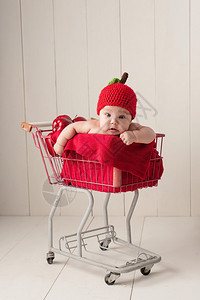 四个月大的女婴戴着一顶手织的苹果帽子图片