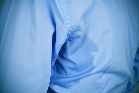 一个穿着蓝色衬衫身上有下臂汗渍的图片