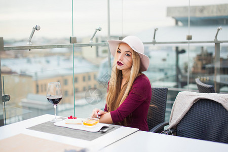 感年轻女子在酒廊吧咖啡厅喝红酒的户外时尚形象图片