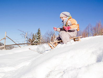 小女孩在雪橇上滑雪在山图片