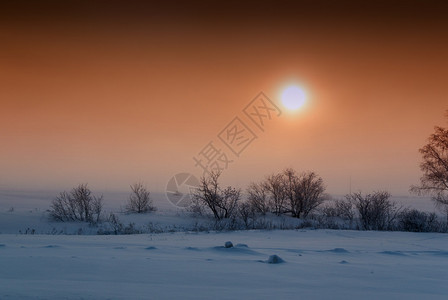 太阳与橙色云层的天空交汇着新的雪地图片