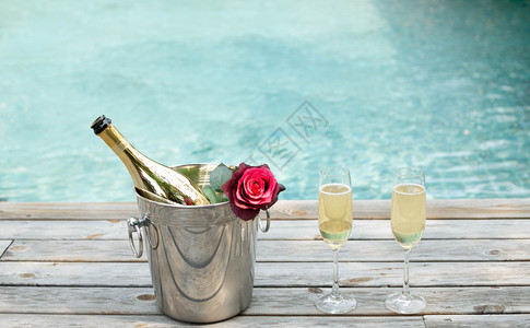 香槟瓶装在冰桶里用游泳池背景图片