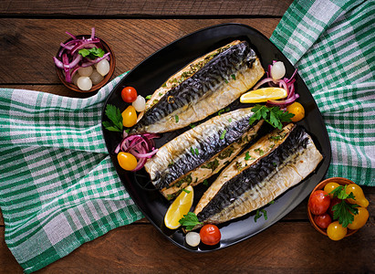 用香草烤鲭鱼用柠檬和泡菜装饰背景图片
