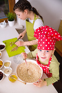 快乐的姐妹们一起做饭年幼快乐的孩子孩子家庭玩得开心图片