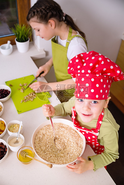 快乐的姐妹们一起做饭年幼快乐的孩子孩子家庭玩得开心图片