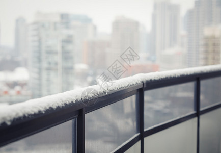 带玻璃的阳台黑色栏杆冬雪模糊的城镇背景文本的复制空间图片