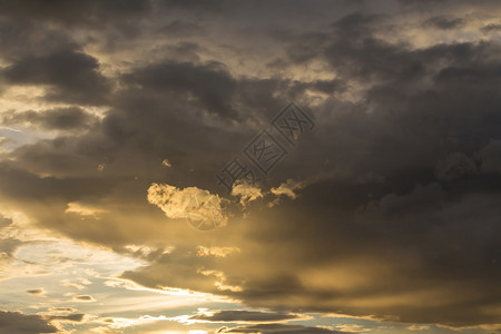 金色的日落天空和发亮的云彩暴风图片