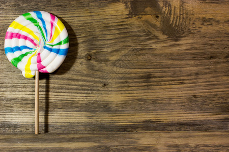 木制背景上的圆形螺旋彩色糖果图片