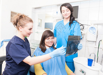 微笑的女牙医向一位美丽的女病人解释X射线的细节图片