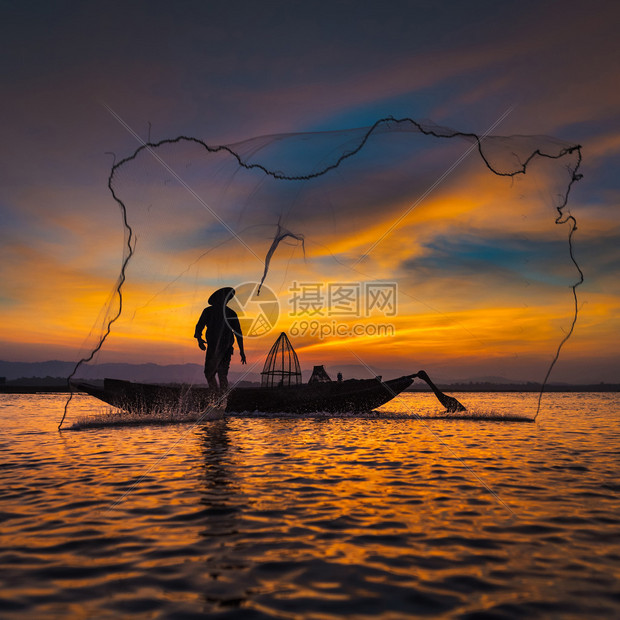 亚洲渔民在木船上的剪影在日出前的清晨在自然河中撒网捕淡水鱼图片