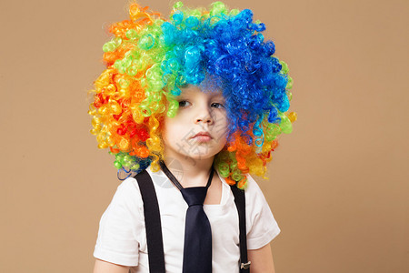 悲伤的小丑戴着小丑假发的小男孩微笑着玩得开心有大五颜六色的假发的周到的小丑男孩寿星有五颜六色的头发的小丑男孩图片