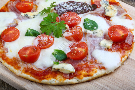 比萨配马苏里拉奶酪和意大利熏火腿配绿叶图片