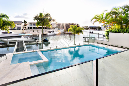 海洋主题酒店美丽的阳光落在海岸豪华住宅的游泳池上背景
