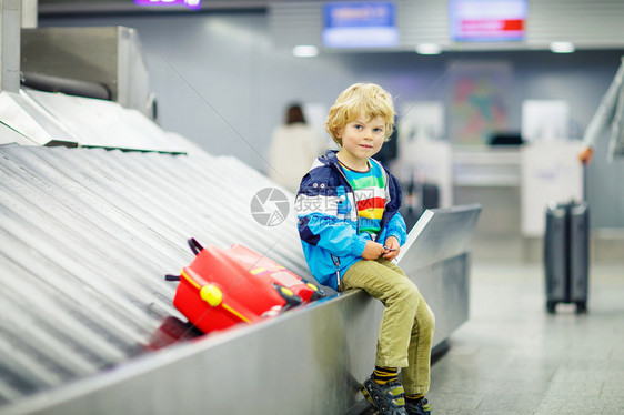 可爱的疲倦小男孩在机场旅行快乐的孩子带着孩子的手提箱在行李传送带上等待因飞行员罢图片
