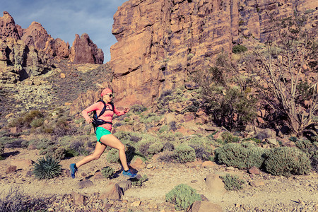 美女跑步者在大自然中背着包在户外慢跑和训练图片