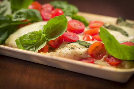 烤卡普雷塞鸡配马苏里拉奶酪罗勒和西红柿背景图片