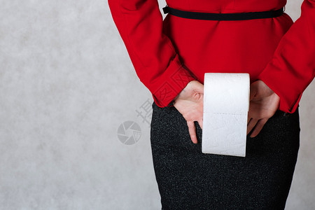 年轻女人把一卷卫生纸贴在屁股上紧背景