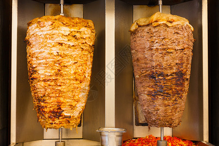 美味的烤串快餐沙威玛鸡肉和羊肉在烤肉叉上并排转动这是中东快餐中常图片