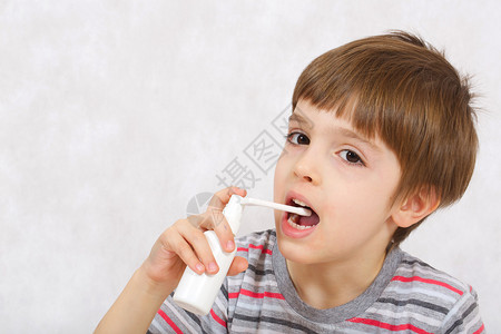 一个六岁的男孩在喉咙里喷药图片