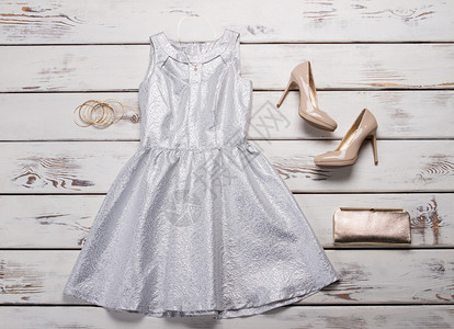 银色连衣裙搭配米色鞋子木桌上的银色连衣裙女士奢华晚装图片