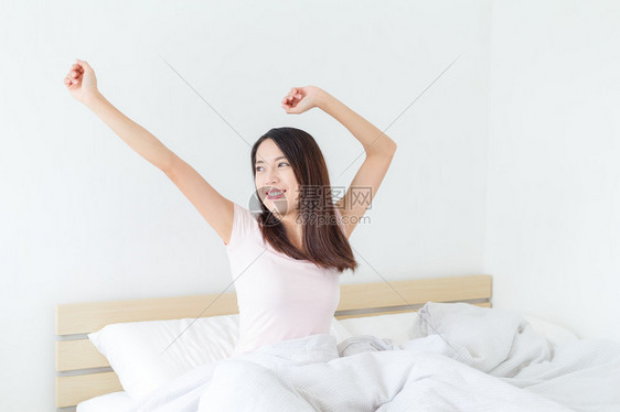亚洲年轻女子早上醒来后伸展身体图片